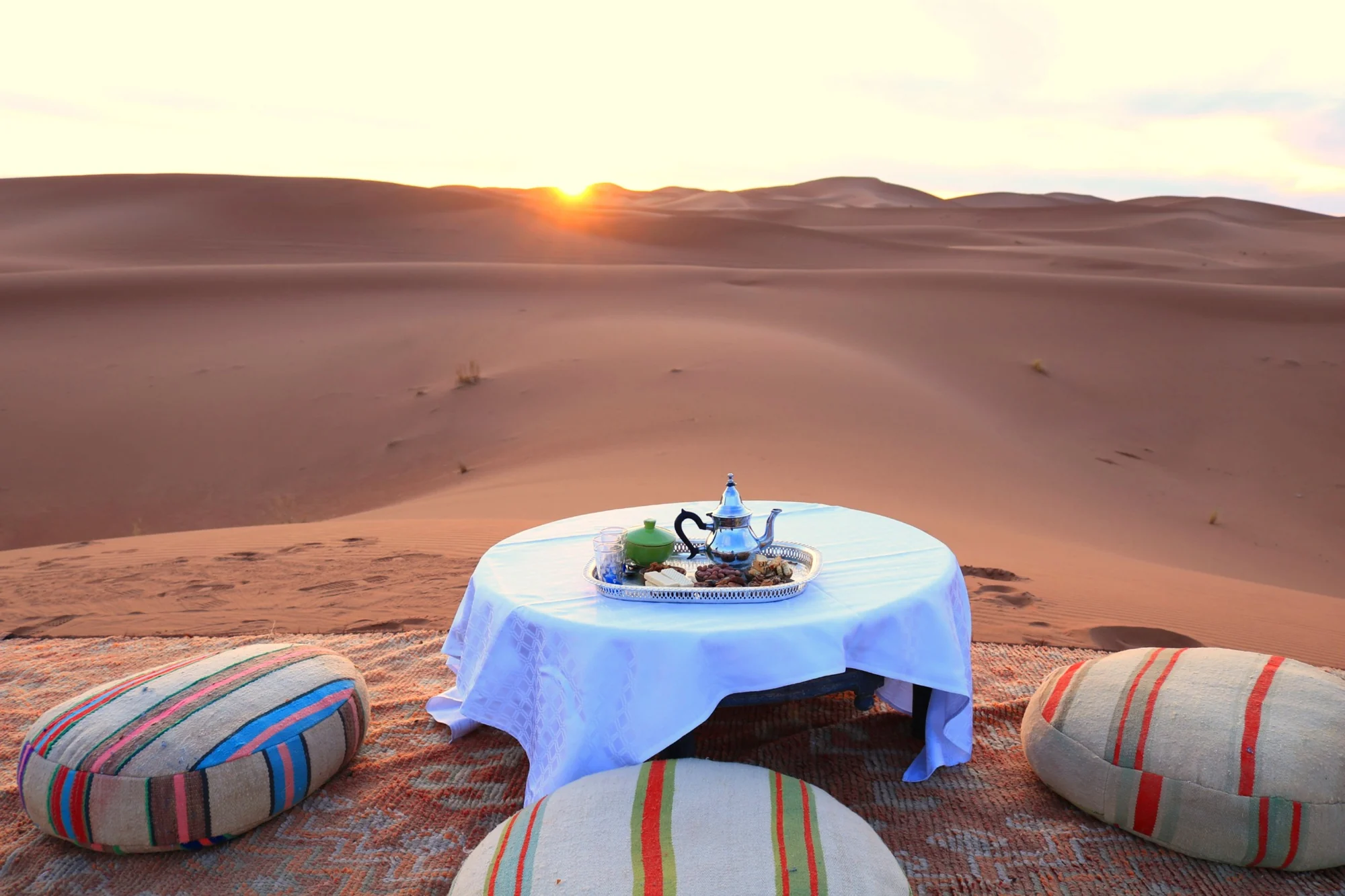 Mesa preparada para compartir té frente a las dunas al atardecer